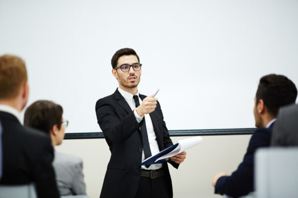 Confident coach pointing at one of listeners while making report at training, Authorized Veeam training