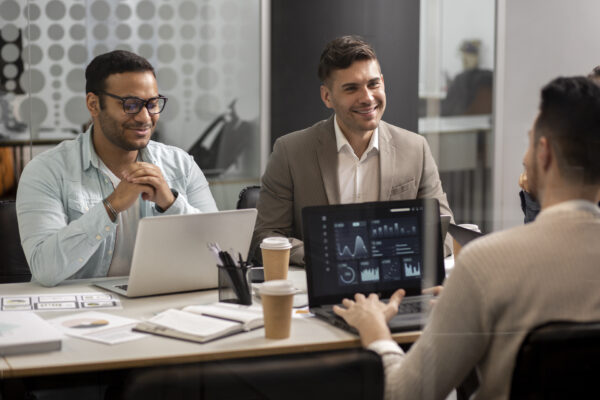 Business team in a modern office discussing data analytics on laptops during a strategy meeting, Citrix virtual apps and desktops administration