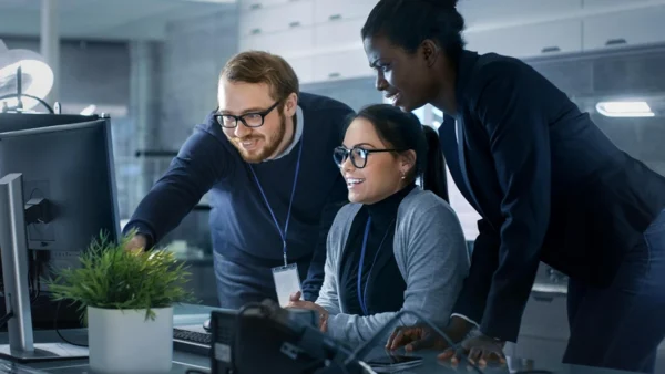 IT professionals collaborating at a computer workstation during a Nutanix as a Service training session.